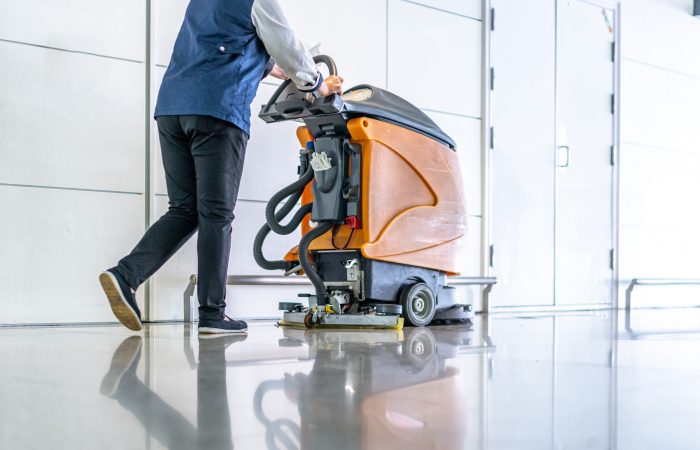 Mann reinigt mit Gerät den Boden